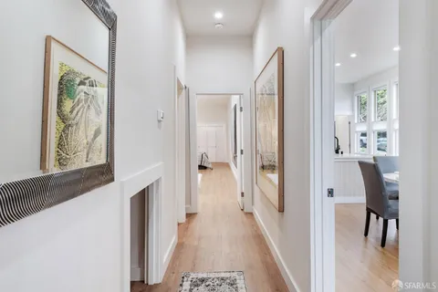 a view of a hallway with wooden floor and dining room