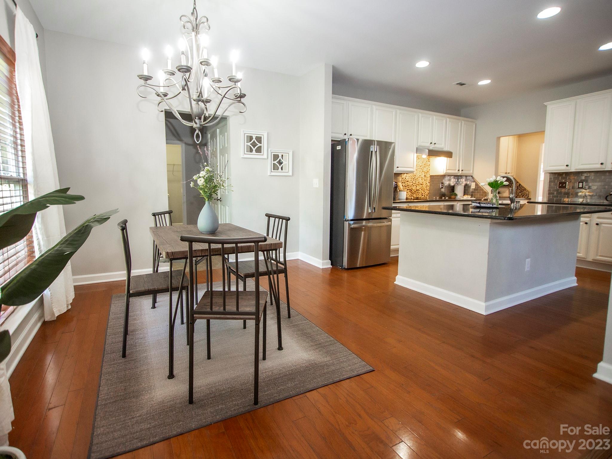 3437 Norwich Road Fort Mill, SC 29715 - Photo 14 of 46 a view of a dining room with furniture a chandelier and wooden floor