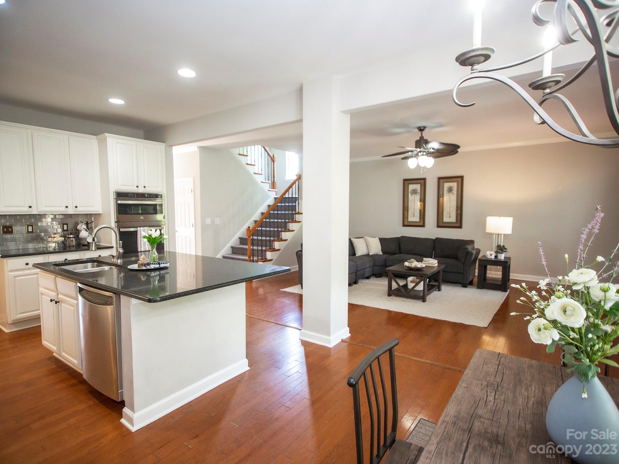 3437 Norwich Road Fort Mill, SC 29715 - Photo 15 of 46 a kitchen with stainless steel appliances kitchen island granite countertop a stove top oven a sink a dining table and chairs with wooden floor