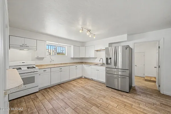 a kitchen with white cabinets and white appliances