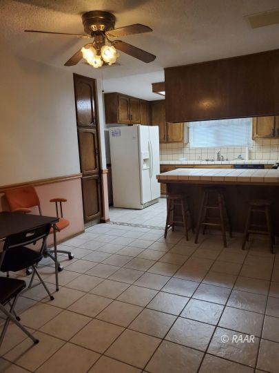 342 East Wilson Avenue Ridgecrest, CA 93555 - Photo 7 of 27 a living room with a table chairs and a refrigerator