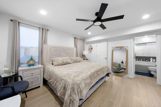 a bedroom with a bed mirror and a window