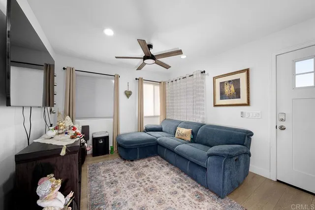 a living room with furniture ceiling fan and a window