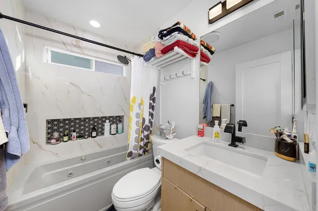 a bathroom with a sink toilet vanity and tub