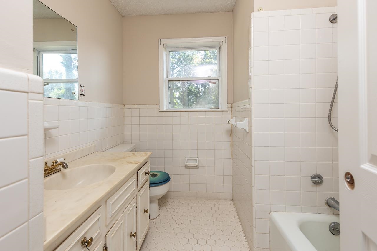 2718 Kate Bond Road Memphis, TN 38133 - Photo 26 of 39 Bathroom with vanity, healthy amount of natural light, tile walls, bathing tub / shower combination, and wainscoting
