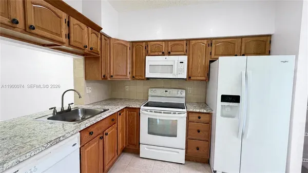 a kitchen with stainless steel appliances granite countertop a refrigerator sink and stove