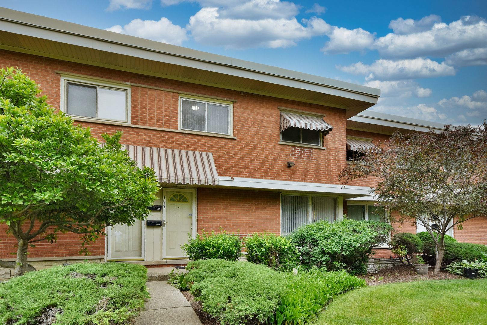 1042 North Wheeling Road, Unit 1042 Mount Prospect, IL 60056 - Photo 1 of 32 a front view of a house with garden