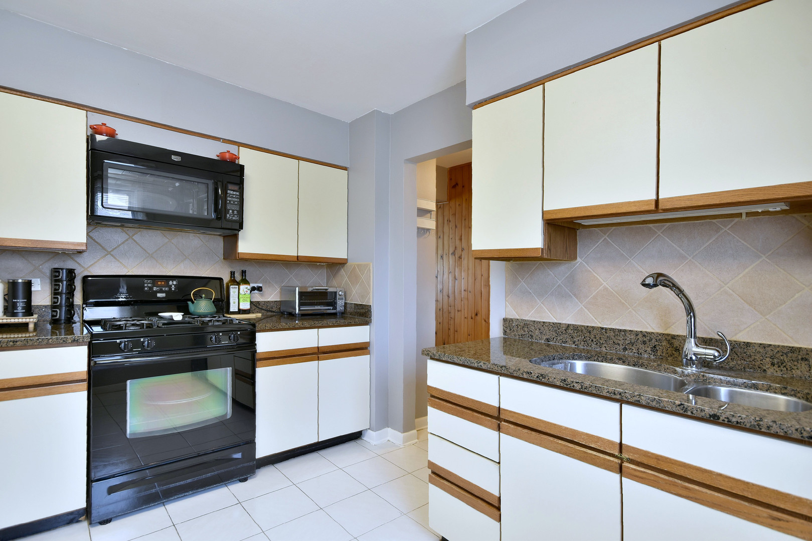 1042 North Wheeling Road, Unit 1042 Mount Prospect, IL 60056 - Photo 11 of 32 a kitchen with stainless steel appliances granite countertop a stove a sink and a microwave