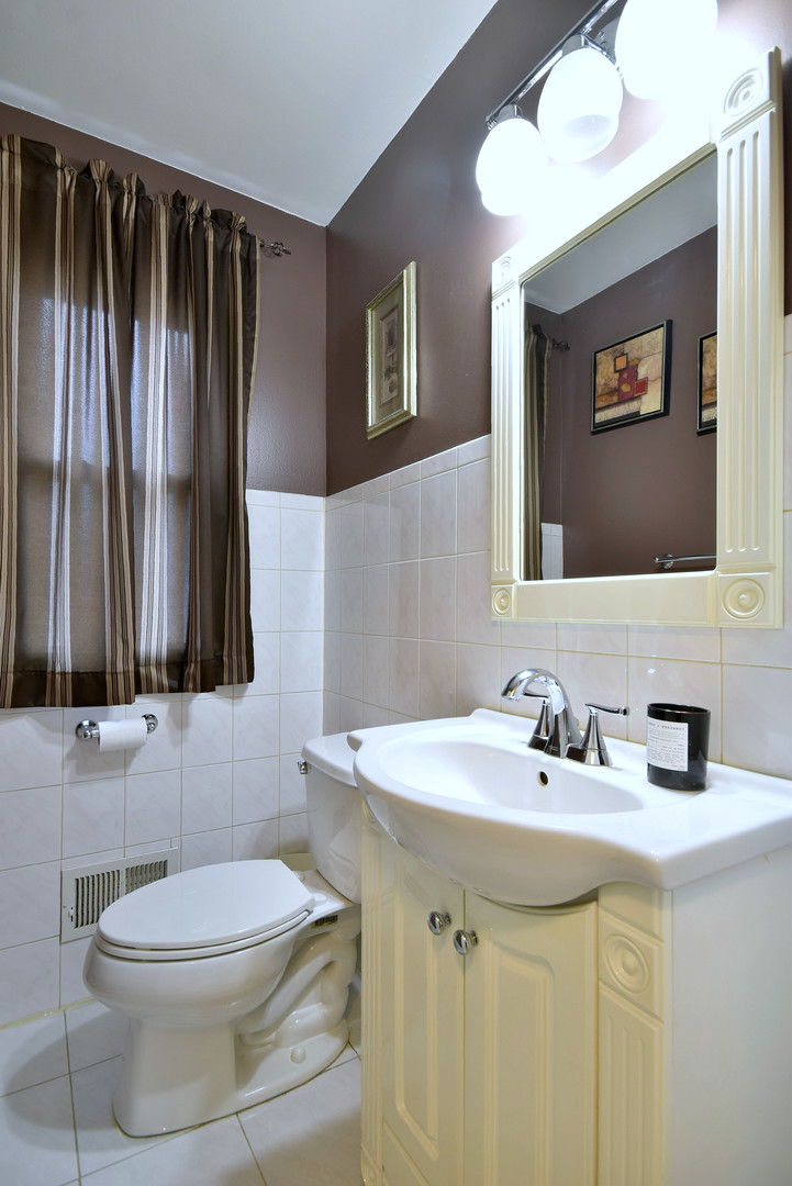 1042 North Wheeling Road, Unit 1042 Mount Prospect, IL 60056 - Photo 20 of 32 a bathroom with a toilet a sink and mirror