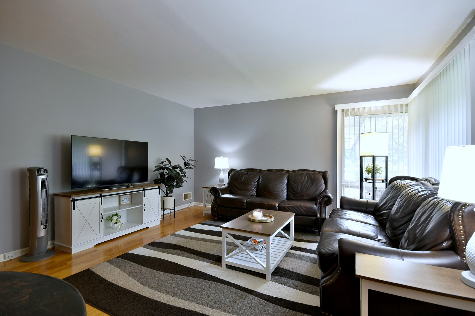 1042 North Wheeling Road, Unit 1042 Mount Prospect, IL 60056 - Photo 3 of 32 a living room with furniture and a flat screen tv