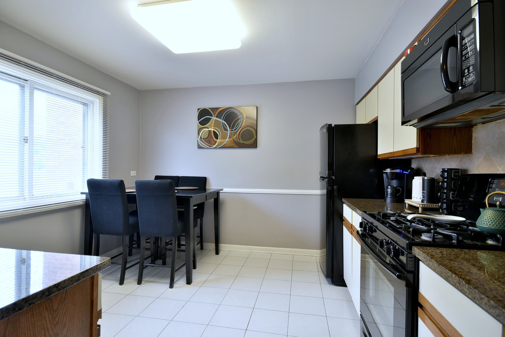 1042 North Wheeling Road, Unit 1042 Mount Prospect, IL 60056 - Photo 10 of 32 a kitchen with stainless steel appliances granite countertop a stove top oven a sink a dining table and chairs