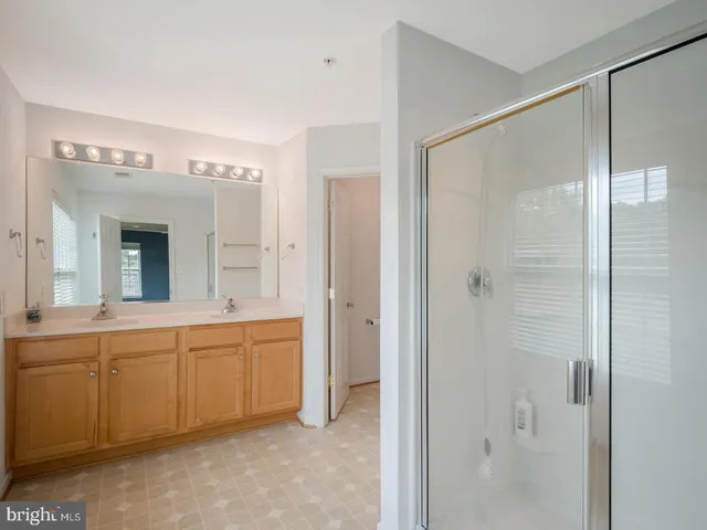 a spacious bathroom with a mirror a shower and a sink