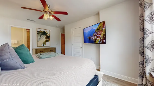 a bedroom with a large bed and a chandelier