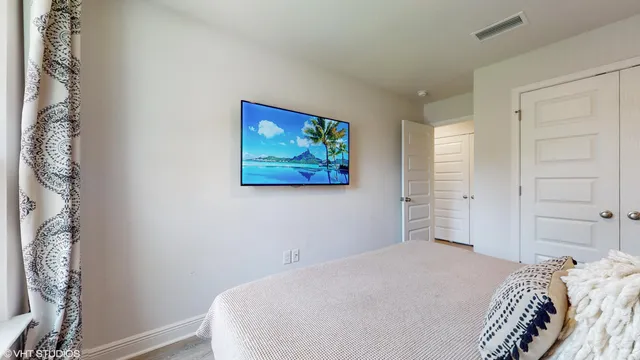 a bedroom with a large bed and a chandelier
