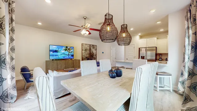 a dining room with wooden floor a chandelier a wooden table and chairs