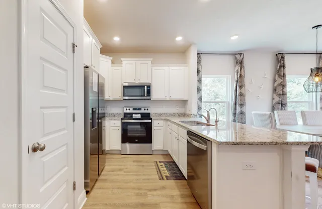 a kitchen with stainless steel appliances granite countertop a stove a sink and a refrigerator