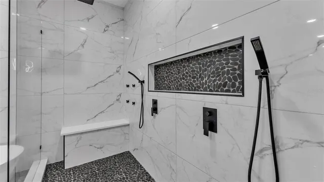 a bathroom with a granite countertop sink a toilet a mirror and shower