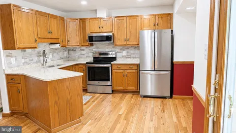 a kitchen with stainless steel appliances granite countertop a refrigerator sink and cabinets