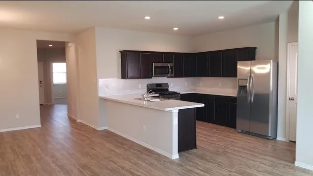 a kitchen with stainless steel appliances granite countertop a sink and a refrigerator