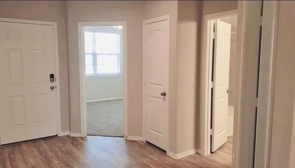 a view of a hallway with wooden floor