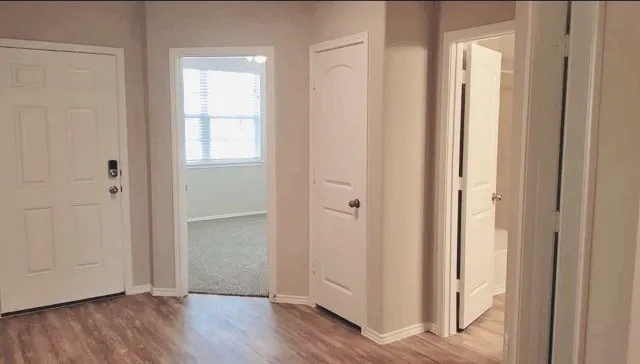 a view of a hallway with wooden floor