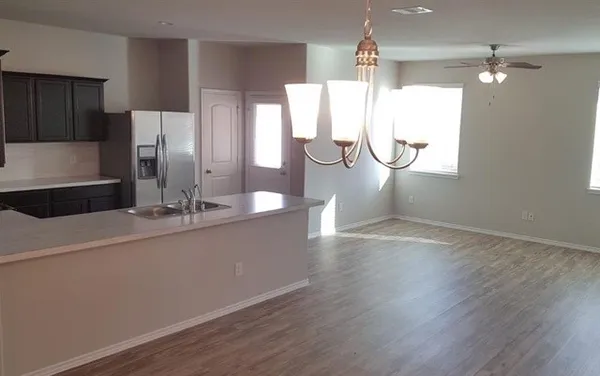 a room with kitchen island a sink and wooden floor