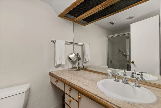 a bathroom with a granite countertop sink a toilet and a mirror