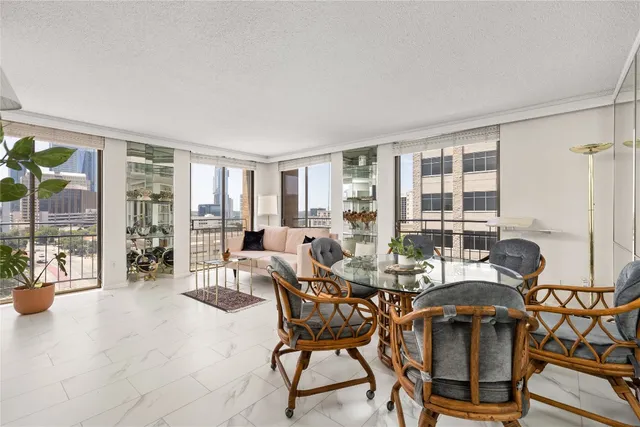 a dining room with furniture and large windows