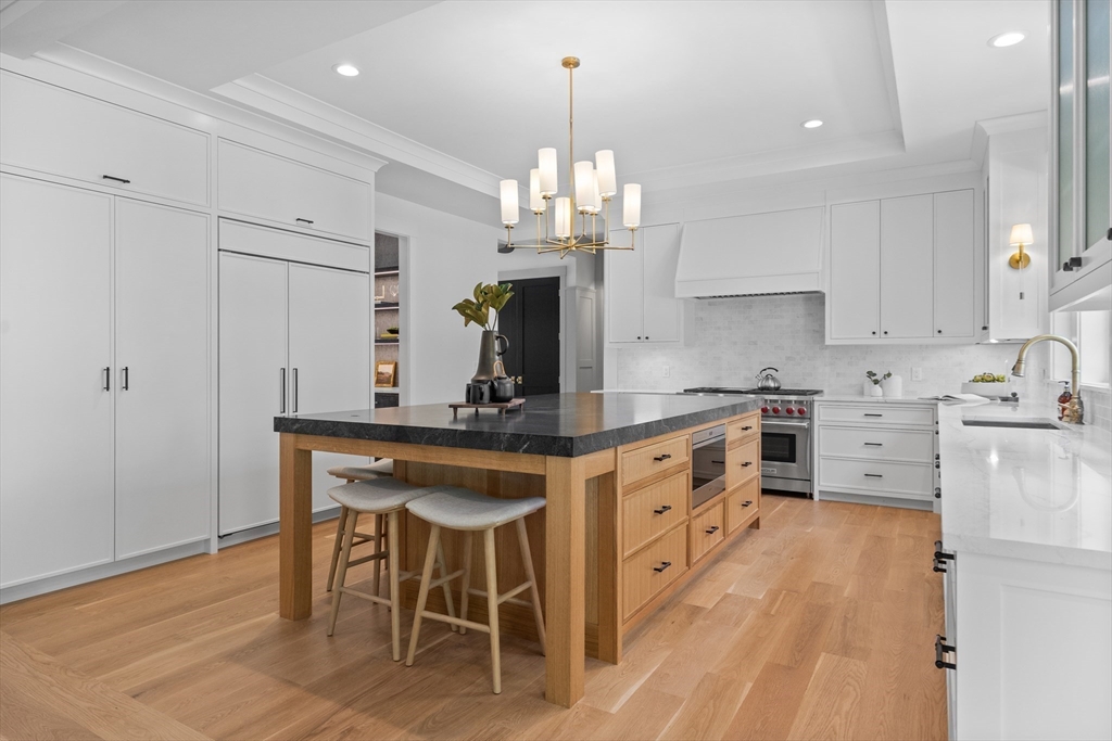 40 White Pine Road Needham, MA 02492 - Photo 10 of 38 a kitchen with stainless steel appliances a kitchen island hardwood floor sink stove and white cabinets