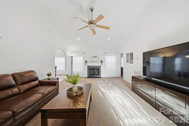 a living room with furniture chandelier and a flat screen tv