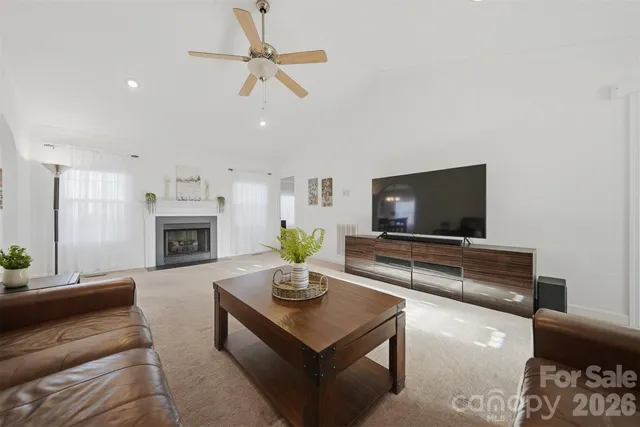 a living room with furniture a fireplace and a flat screen tv