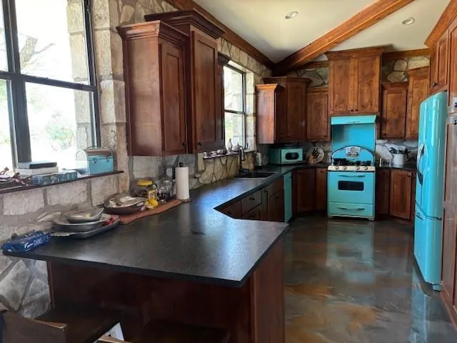a kitchen with stainless steel appliances granite countertop a refrigerator and a stove