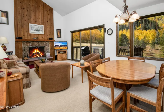a living room with furniture a large window and a fireplace