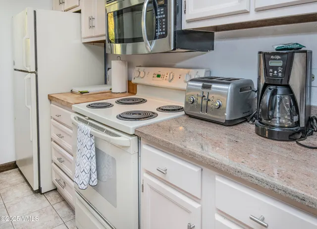 a bathroom with a granite countertop sink a toilet a mirror and a shower