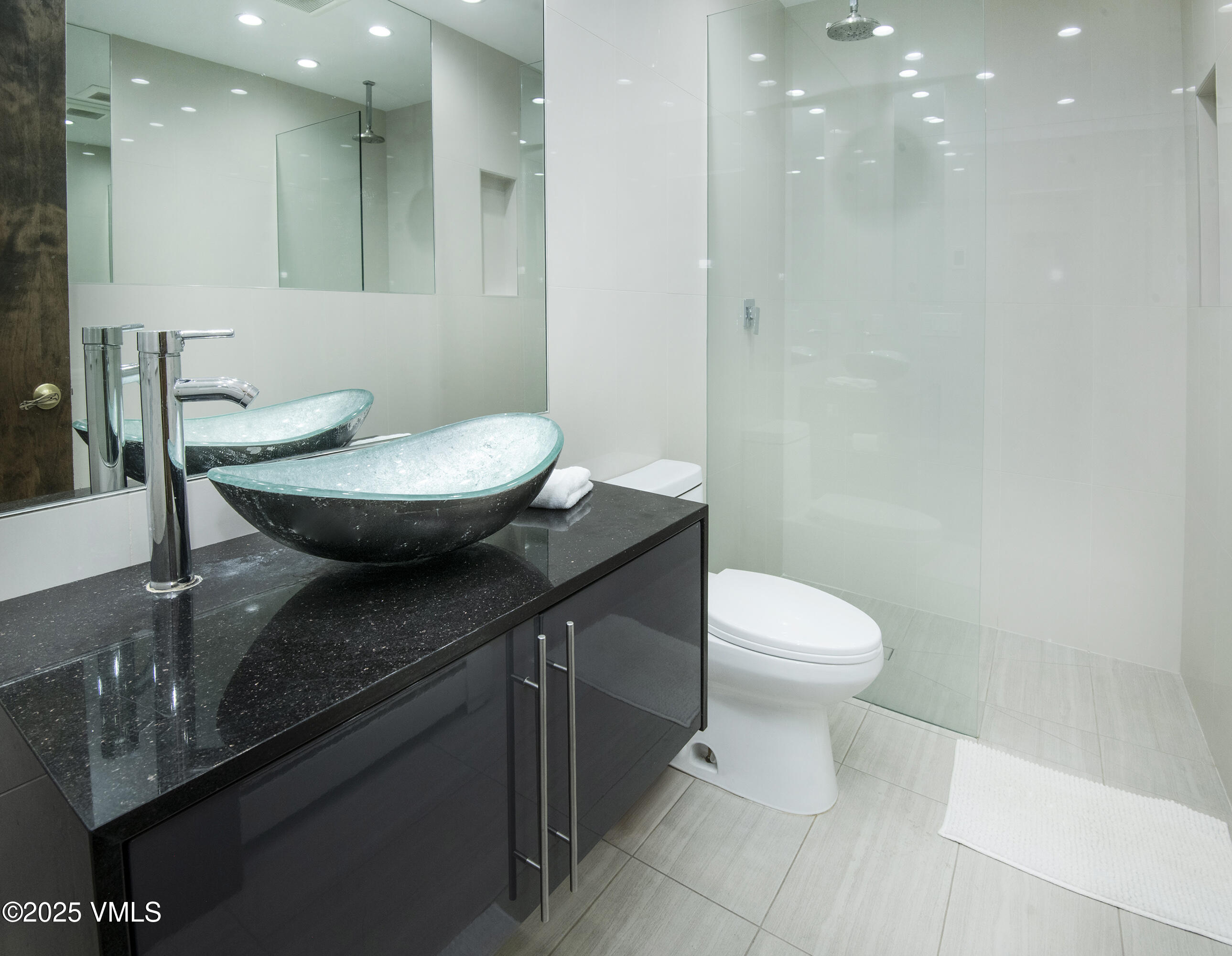 4516 Meadow Drive, Unit 807 Vail, CO 81657 - Photo 16 of 35 a bathroom with a granite countertop sink a toilet a mirror and a shower