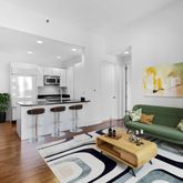 a living room with furniture and kitchen view