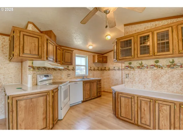a kitchen with kitchen island granite countertop a sink stove and cabinets
