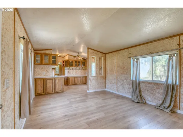 a view of a big room with wooden floor and windows