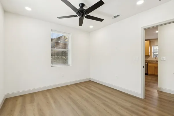 an empty room with wooden floor and windows