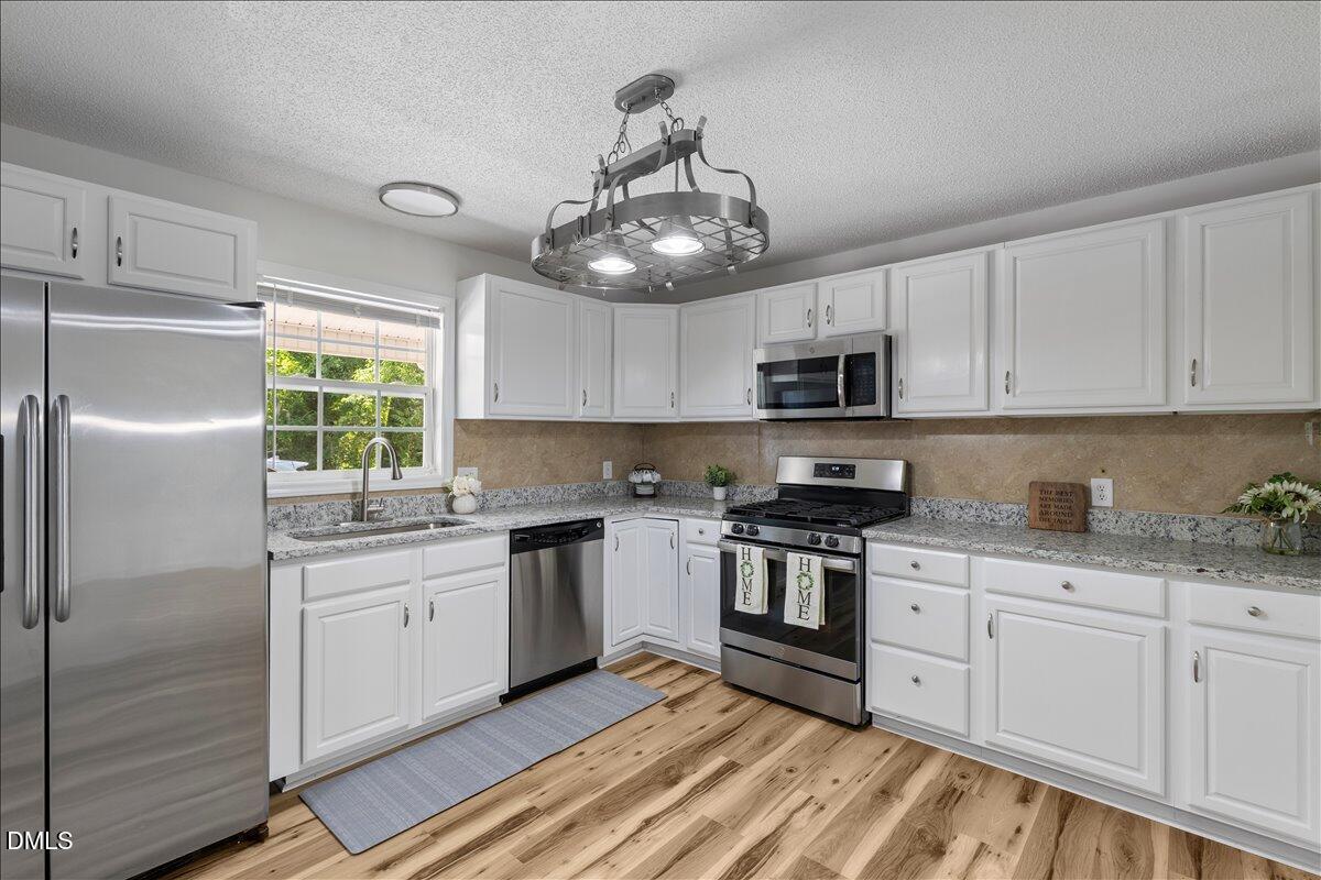 836 South Main Street Roxboro, NC 27573 - Photo 17 of 55 a kitchen with granite countertop stainless steel appliances a stove microwave and sink