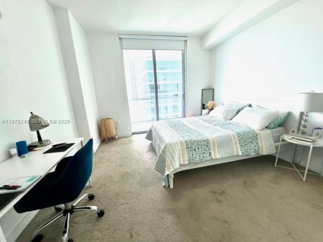 79 Southwest 12th Street, Unit 2010 Miami, FL 33130 - Photo 14 of 20 a bedroom with a bed chair and a window