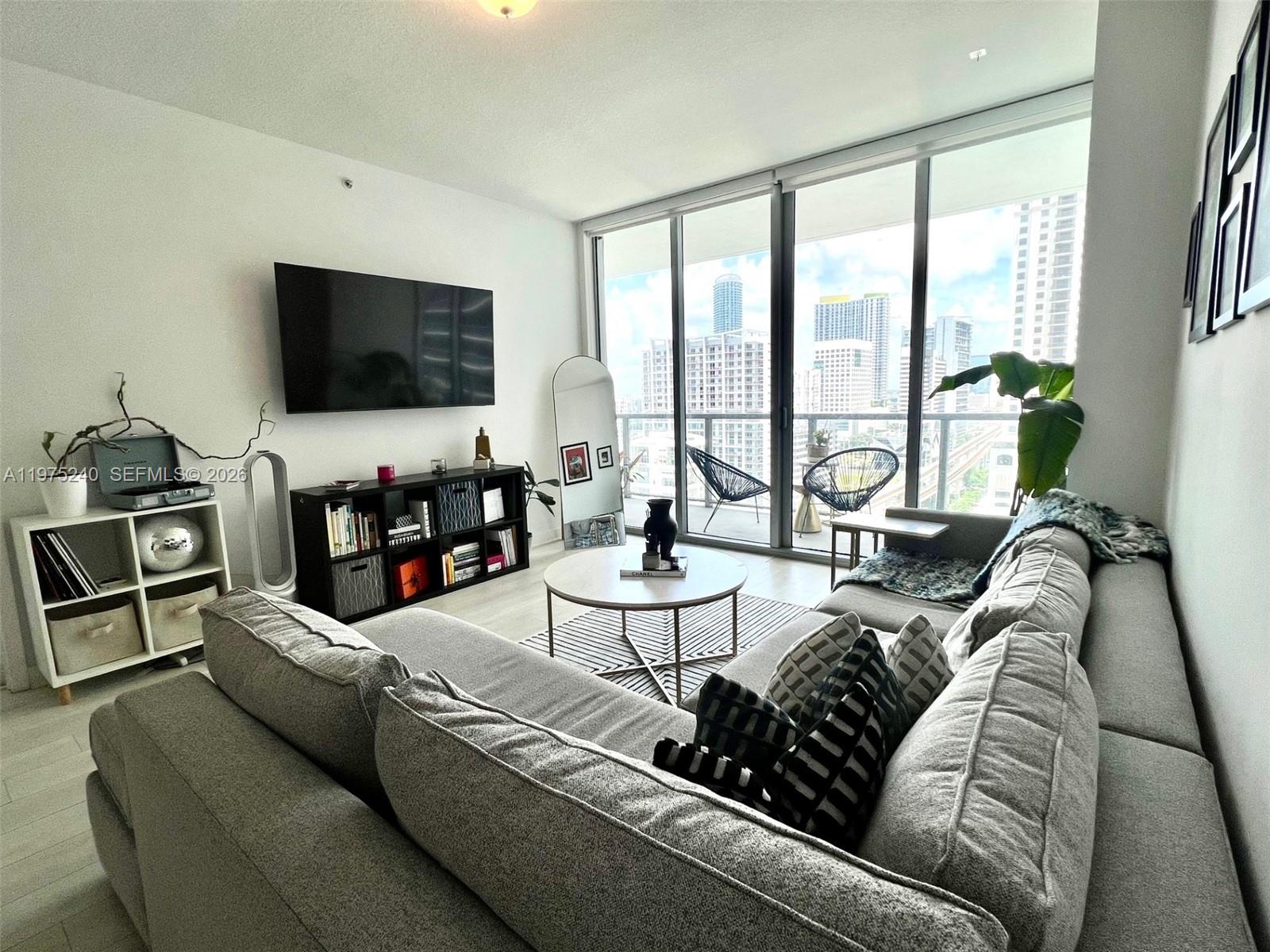 79 Southwest 12th Street, Unit 2010 Miami, FL 33130 - Photo 2 of 20 a living room with furniture and a flat screen tv