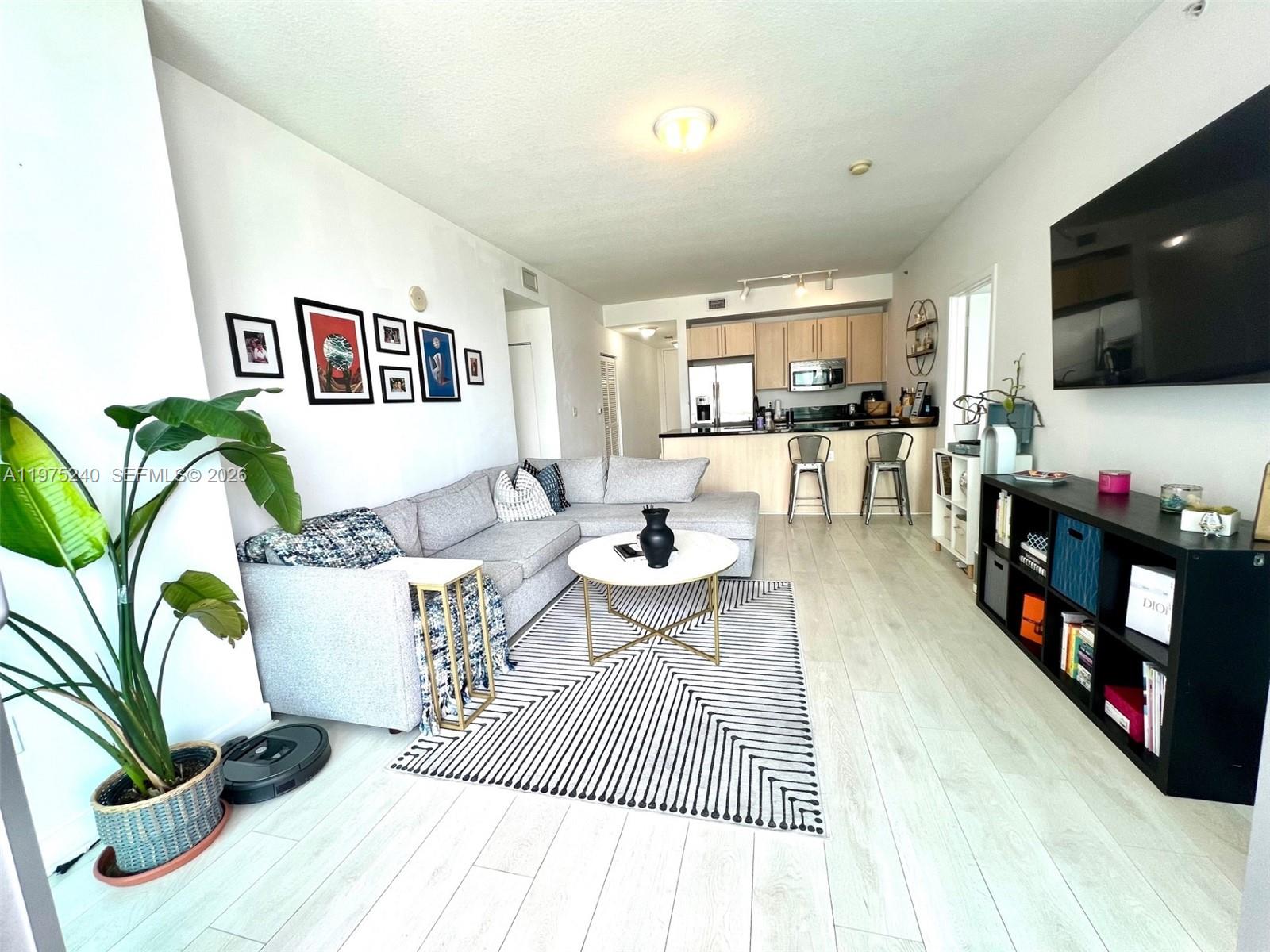 79 Southwest 12th Street, Unit 2010 Miami, FL 33130 - Photo 4 of 20 a living room with furniture and a flat screen tv