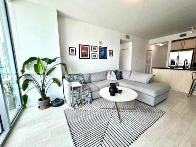 79 Southwest 12th Street, Unit 2010 Miami, FL 33130 - Photo 5 of 20 a living room with furniture and a wooden floor