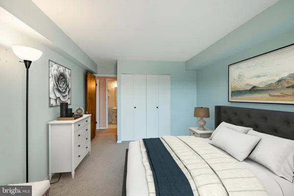 a spacious bedroom with a bed and a large mirror