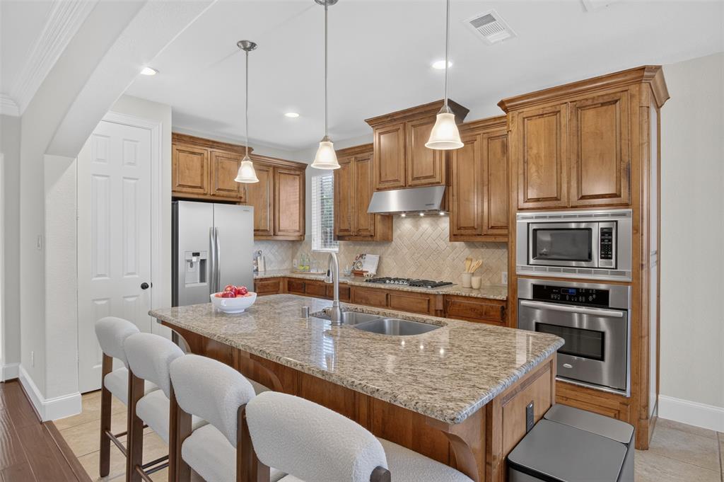 842 Sun Meadow Road Allen, TX 75013 - Photo 6 of 39 Gourmet kitchen with a large island featuring a granite countertop, undermount sink, and pendant lighting