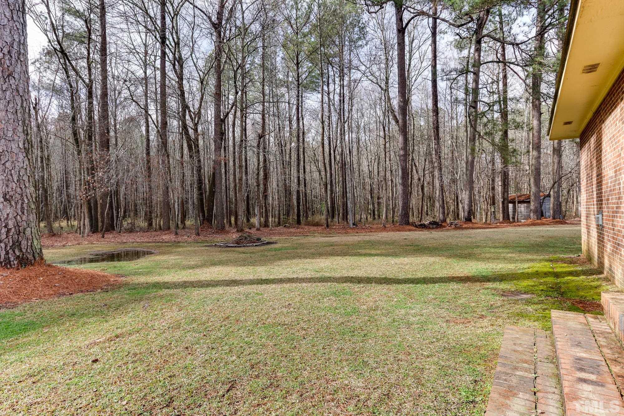 11723 Claude Lewis Road Middlesex, NC 27557 - Photo 23 of 27 a view of swimming pool with large trees and wooden fence