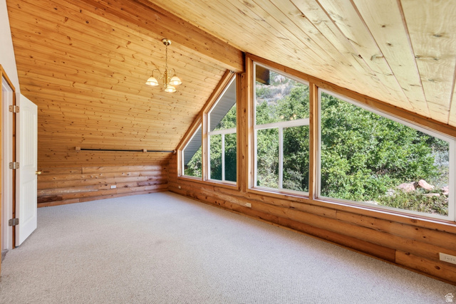 2640 East Weber Canyon Road Oakley, UT 84055 - Photo 34 of 56 Vaulted wood-paneled ceiling, wood-plank walls, large picture windows, and light-toned carpet flooring