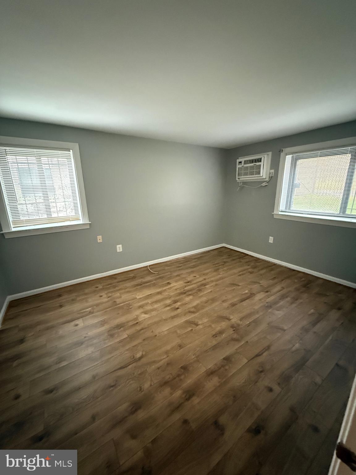 3101 Naylor Road Southeast, Unit 104 Washington, DC 20020 - Photo 3 of 13 an empty room with wooden floor and windows