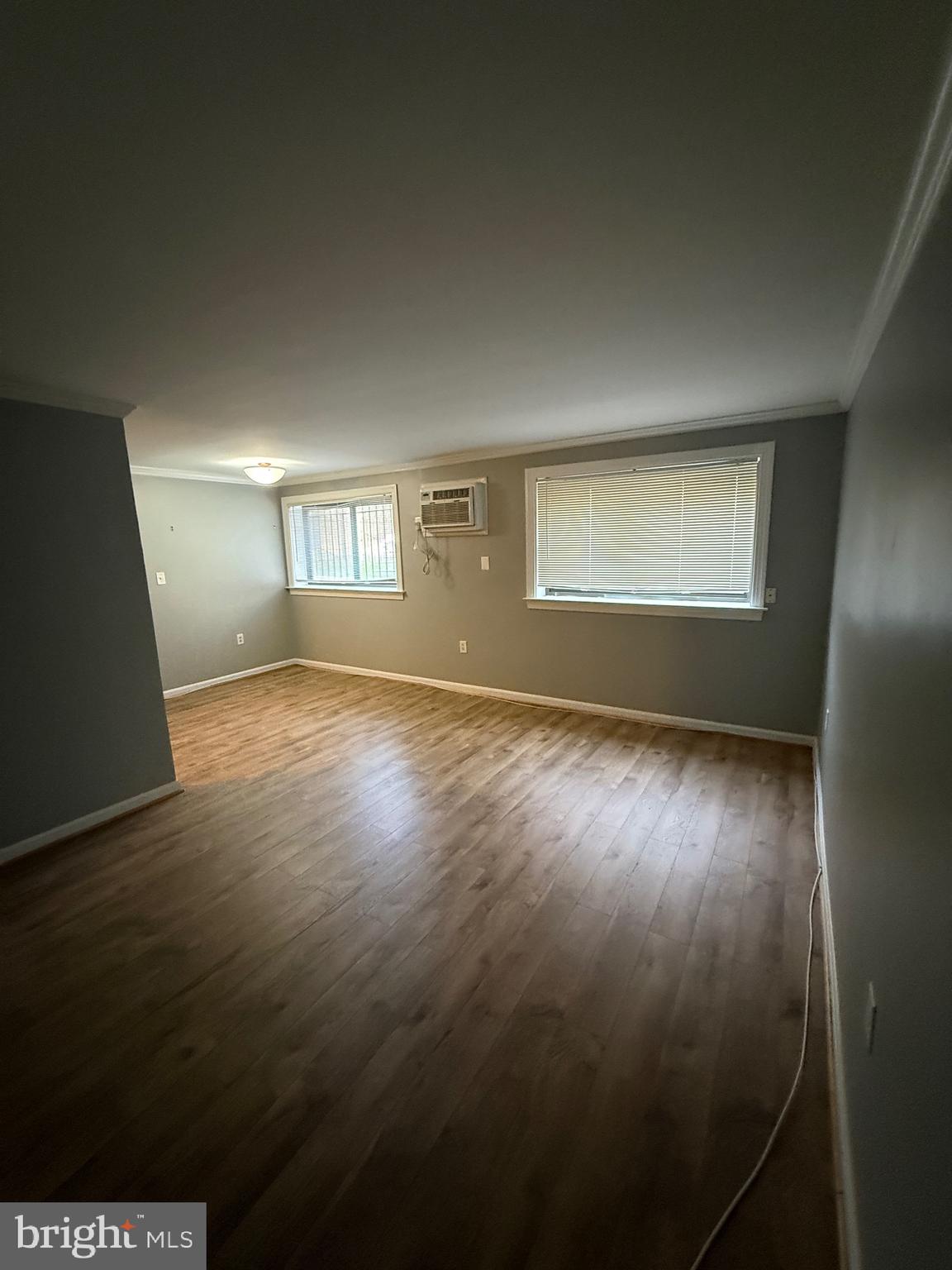 3101 Naylor Road Southeast, Unit 104 Washington, DC 20020 - Photo 10 of 13 an empty room with wooden floor and windows